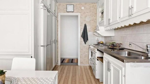 A compact kitchen with white cabinets, a stainless steel sink, and a small countertop. - Cozy apartment near Volvo Cars (Gothenburg)