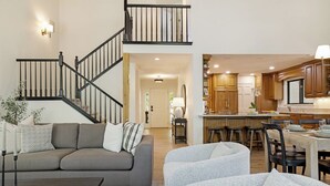 A modern living room with a staircase, a dining area, and a kitchen. - 6 BR Mountain Golf Retreat, Hot Tub, Fall Foliage Views, Trailhead Steps Away (Avon)