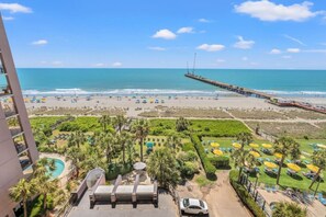 Ein Hotel mit Pool, Meerblick und einer in den Ozean ragenden Mole.
