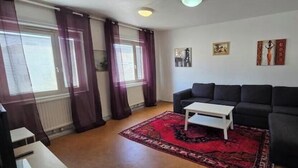 Una sala de estar con un sofá, una mesa de centro y un tapete estampado.