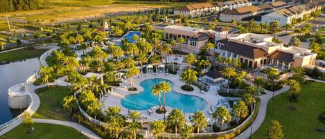 Ein Resort mit zentralem Pool, mehreren Gebäuden und umgebender Bepflanzung.