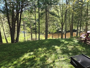 Una mesa de picnic en un área boscosa, con un río al fondo.