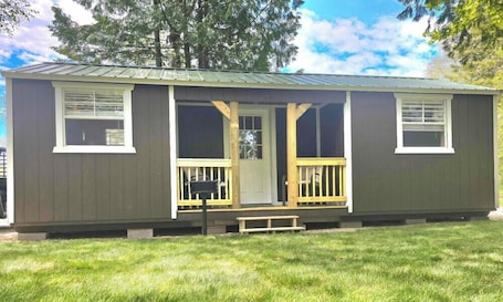 A single-story mobile home with a porch, a front door, and two windows.. The Turtle/Mikinak Cabin, located within 35-40 minutes from Pictured Rocks