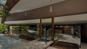 Ein modernes Gebäude mit Glastür, Wasserspiel und Fliesenboden.