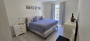 A bedroom with a bed, bedside tables, a desk, and a window with curtains. - Last Minute Disney Getaway! Luxury Condo with Private Balcony. Book Now! #173229 (Orlando)