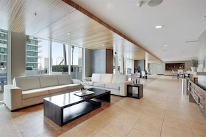 A spacious living area with a sofa, coffee table, and a dining area with a kitchen in the background. - Miami 184 - One Bedroom Apartment, Sleeps 4 (Miami)