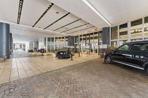 A spacious lobby with a modern design, featuring a large entrance, a black SUV, and a brick-patterned floor. - Miami 184 - One Bedroom Apartment, Sleeps 4 (Miami)