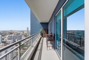 A balcony with a view of a cityscape, a table with chairs, and a potted plant. - Miami 184 - One Bedroom Apartment, Sleeps 4 (Miami)