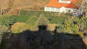 A residential area with a house featuring a red roof, surrounded by greenery and buildings in the background. - Spacious Family Stay in Oostduinkerke (Koksijde)