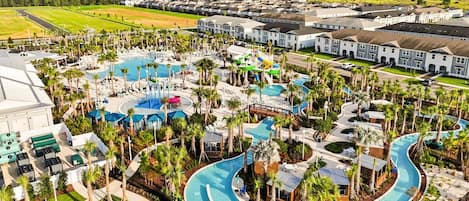 A resort with multiple swimming pools, palm trees, and a large building complex.