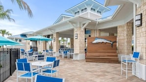 An outdoor patio area with tables and chairs, a wooden bench, and a covered seating area. - Last Minute Disney Getaway! Private Pool, Game Room & Themed Bedrooms. Book Now! #173751 (Orlando)