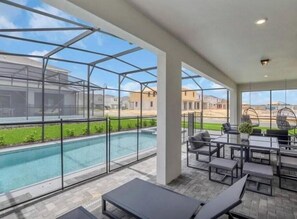 A covered outdoor area with a pool, seating, and a view of the neighborhood. - Last Minute Disney Getaway! Private Pool, Game Room & Themed Bedrooms. Book Now! #173751 (Orlando)