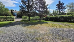 A gravel driveway leading to a house with a lawn and trees. - Newly built studio apartment (Gothenburg)