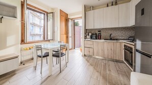 A modern kitchen with a dining area, wooden cabinets, and a built-in oven. - EasyComo - Holiday Home MM (Como)
