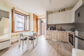 Eine moderne Küche mit Essbereich, Holzschränken und einem Einbauofen.