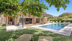 A poolside area with lounge chairs, a dining area, and a covered patio. - Villa 10 pers with swimming pool, close to the sea (La Croix-Valmer)
