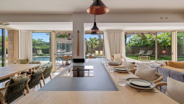 A spacious dining area with a long table, chairs, and a central island. - Villa 10 pers with swimming pool, close to the sea (La Croix-Valmer)
