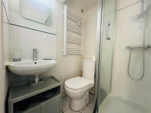 Ein Badezimmer mit Waschbecken, Toilette und einer Duschkabine aus Glas.