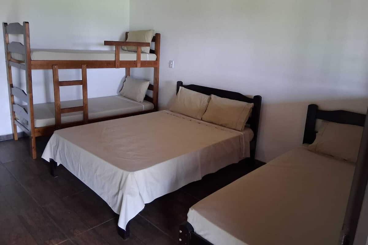 Una habitación con una cama individual, una litera y un escritorio pequeño.
