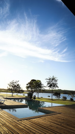 Una terraza de madera con vista despejada a un lago y árboles.