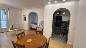 Un espace de vie compact comprenant un coin repas, une kitchenette et une chambre avec fenêtre.