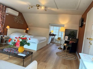 A bedroom with a bed, bedside tables, a desk, a chair, a lamp, and a window.