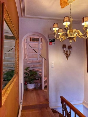 A staircase with a chandelier, a mirror, and a potted plant. - Clemanbruges (Bruges)