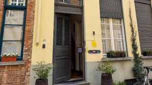 A yellow building with multiple windows, a door, and steps leading to the entrance. - Clemanbruges (Bruges)