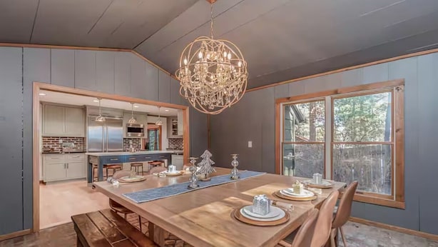 Un'area pranzo con un tavolo in legno, panche e un lampadario.