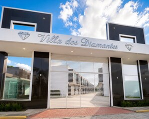 A modern building with a sign reading 'Villa dos Diamantes.' - Fully Furnished Duplex Apartment in Porto Seguro - Swimming Pool - 200m from the Beach (Porto Seguro)