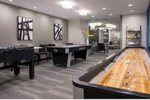Une pièce équipée d’une table de billard, d’un baby-foot et d’une table de jeu de palet.
