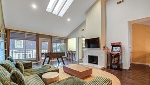 A spacious living room with a fireplace, a large sofa set, and a video game machine. - Kirby Poolhouse - Game Room - Garage - Elevator (Houston)