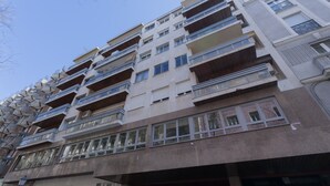 Un edificio residencial de varios pisos con balcones, ventanas grandes y una mezcla de estilos arquitectónicos.