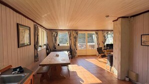 Eine Küche mit Holzwänden, einem Esstisch und einem großen Fenster.