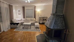 A living room with a sofa, a coffee table, a fireplace, and a patterned rug. - Villa Apartment in the best part of Gothenburg (Gothenburg)