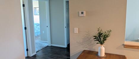 An interior space with a wooden table, a white wall, and a door leading to another room.