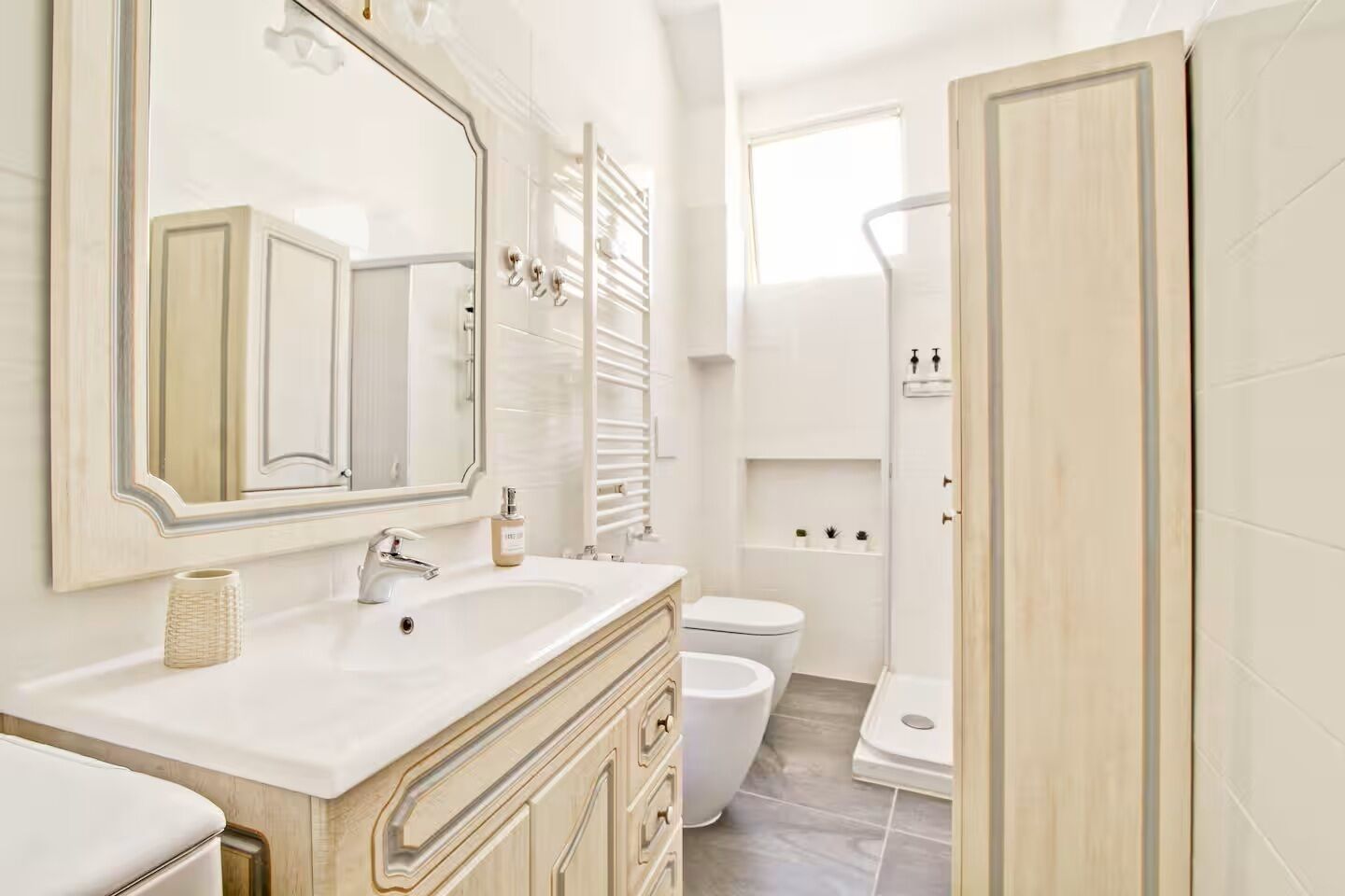 A bathroom with a large mirror, a sink, a toilet, and a shower area.