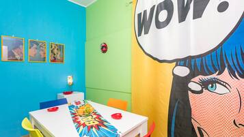 A room with a blue wall, a white table, and a colorful comic book-style banner.