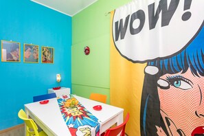 A room with a blue wall, a white table, and a colorful comic book-style banner.