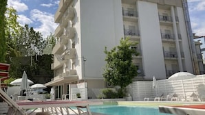 Ein modernes Gebäude mit Schwimmbad, Außenbereich und blauem Himmel.