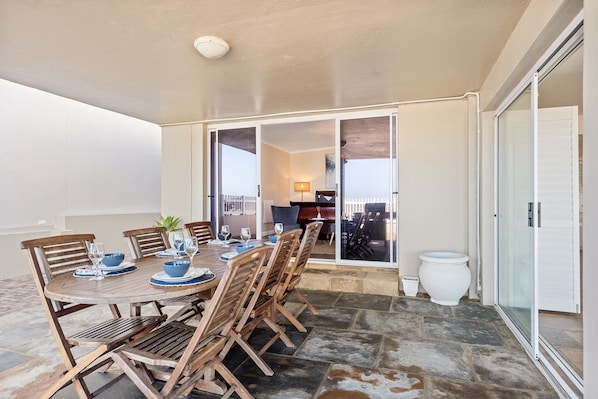 A dining area with a round table, wooden chairs, and a potted plant.