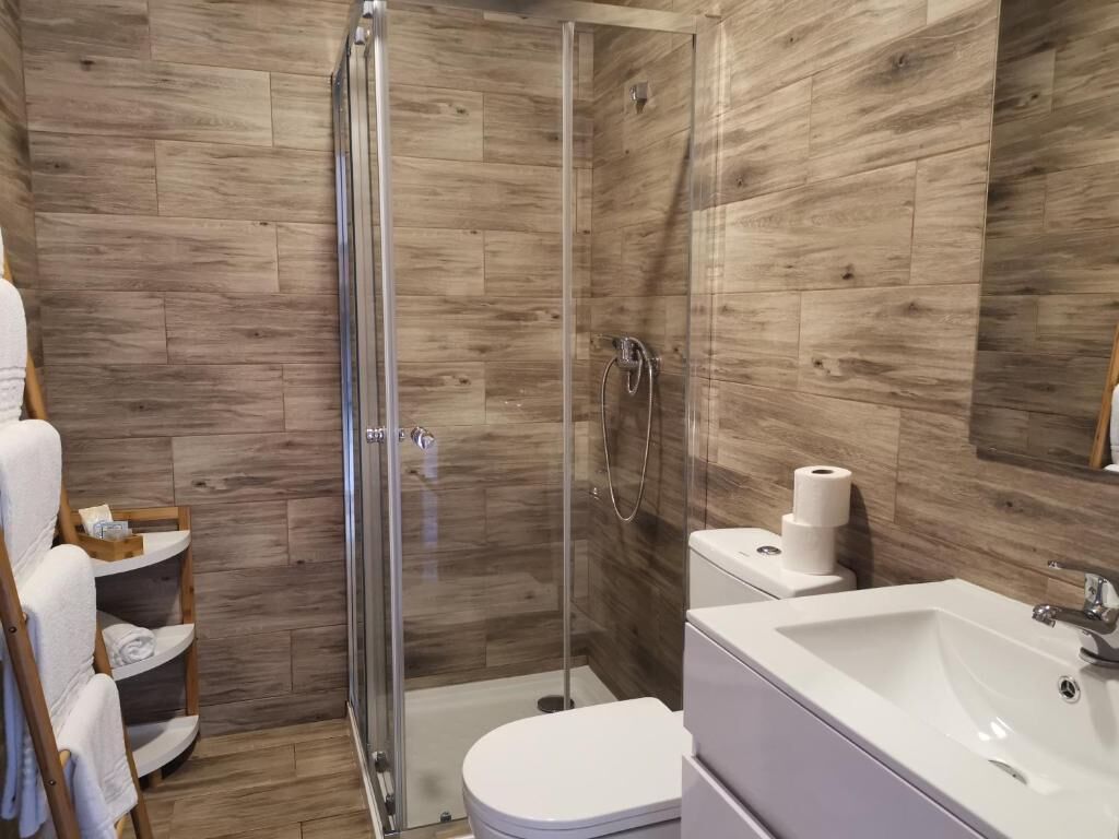 Une salle de bain moderne équipée d’une douche, de toilettes et d’un lavabo.