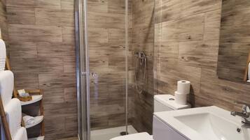 Une salle de bain moderne équipée d’une douche, de toilettes et d’un lavabo.