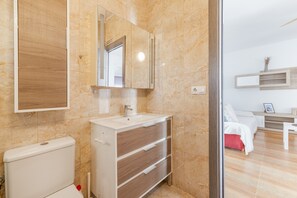 Ein Badezimmer mit Toilette, Waschbecken und Spiegel.