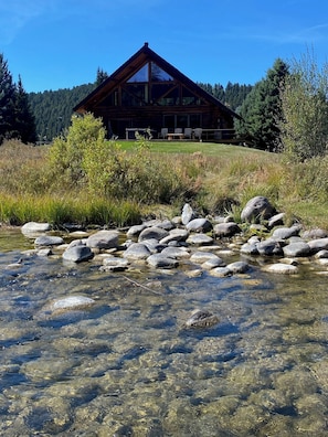 Eine Lodge mit freiem Blick auf einen felsigen Bach vor der Tür.