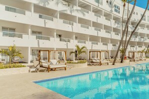 Ein Hotel mit Pool, mehreren Balkonen und Liegestühlen.