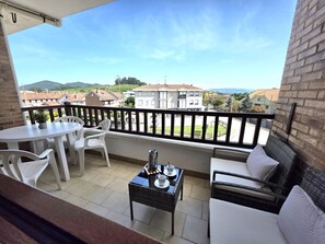 Un balcon avec une table, des chaises, un canapé et une table basse.