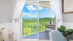 A balcony with a view of the ocean, a table with a bottle, and two decorative swans. - Atlantic Serenity 2407 Ocean Pointe 2 BA 2 BR (Tavernier)