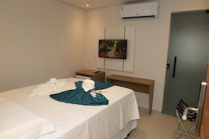 A hotel room with a bed, a desk, a TV, and an air conditioning unit. - Mairí Hotel (Itaituba)