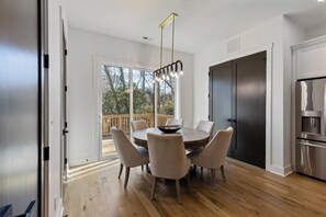 Eine moderne Küche mit Essbereich, großen Fenstern und Blick ins Freie.